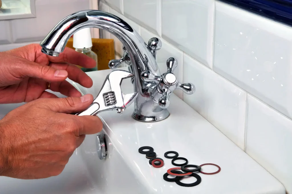 Plumber performing maintenance on a bathroom faucet in Canton