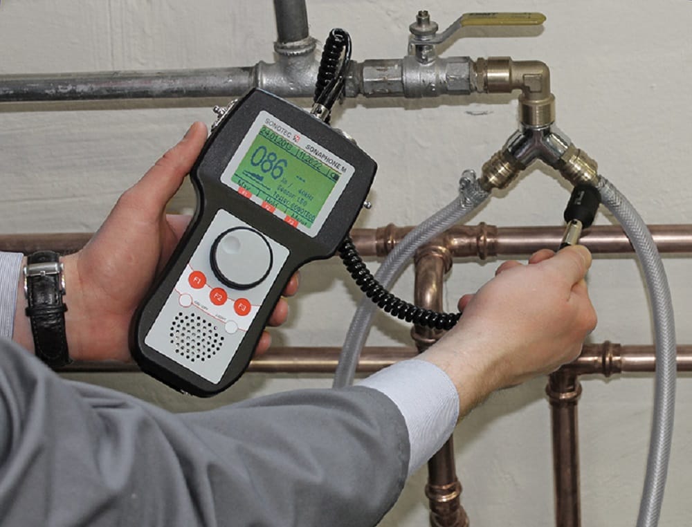 Plumber testing pipes with electronic leak detection equipment in Canton