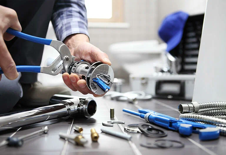 Technician repairing a plumbing fixture with professional tools in Canton