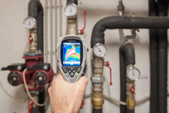 Plumber using a thermal imaging camera to inspect pipes in Canton