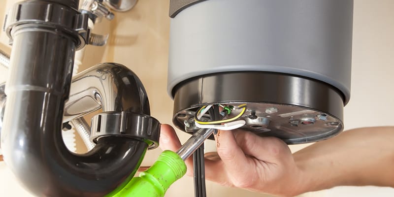 Technician repairing the heating element of a water heater in Canton