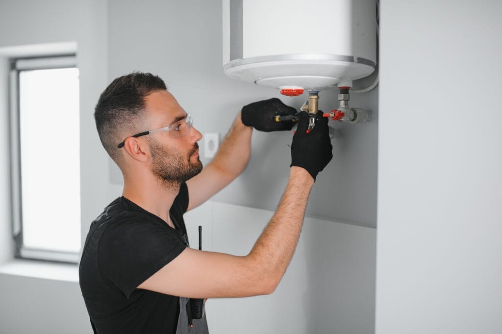 Technician performing water heater maintenance in Canton