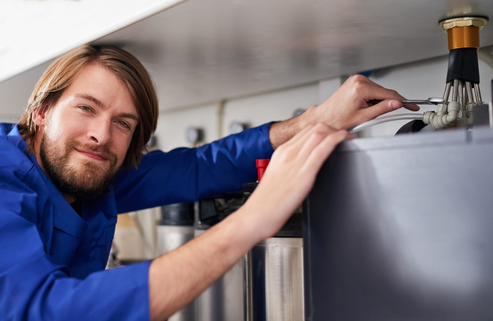Technician servicing a residential water heater tank in Canton