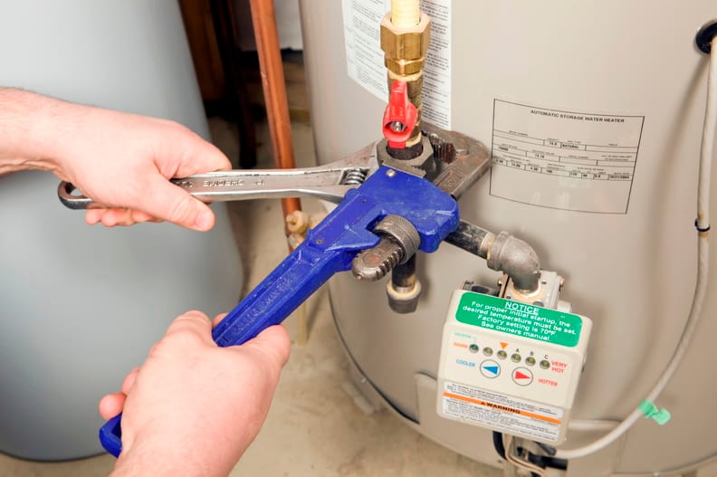 Plumber repairing a water heater valve in Canton